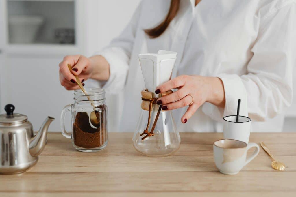 Woman making coffee using Chemex. 