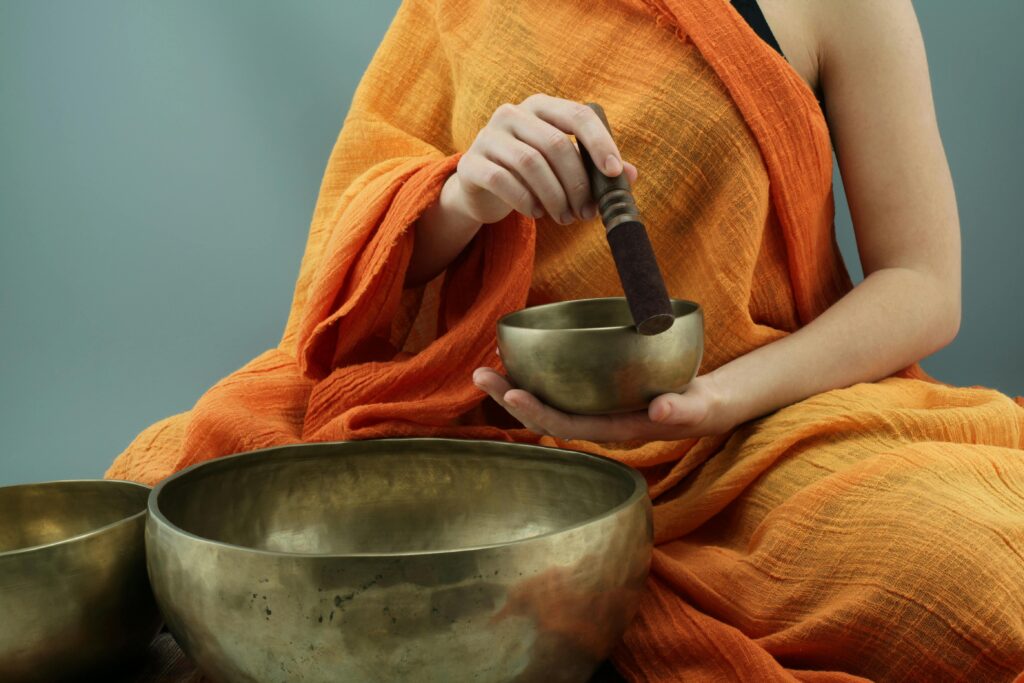 A close-up view of a monk holding meditation cups.