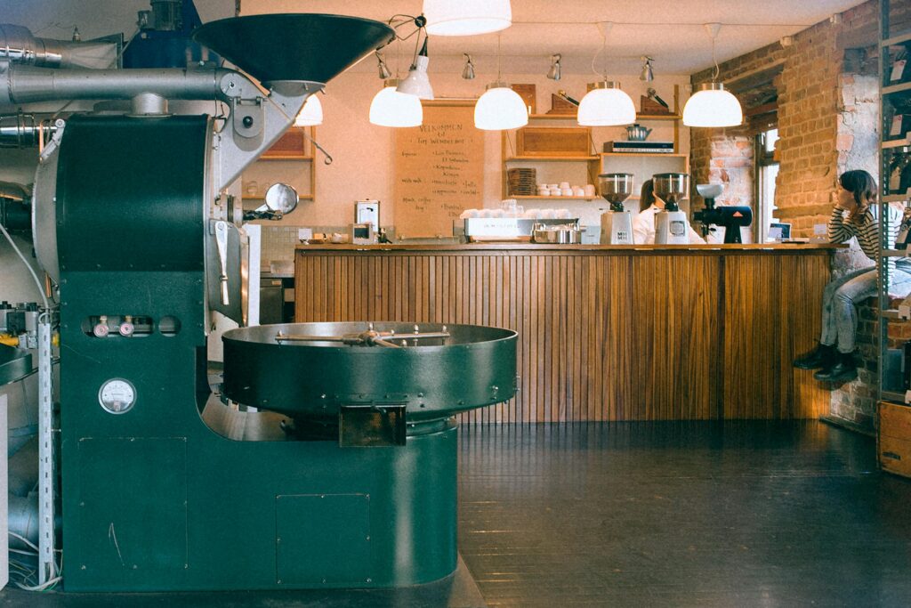 A green coffee roasting machine in a cafe.